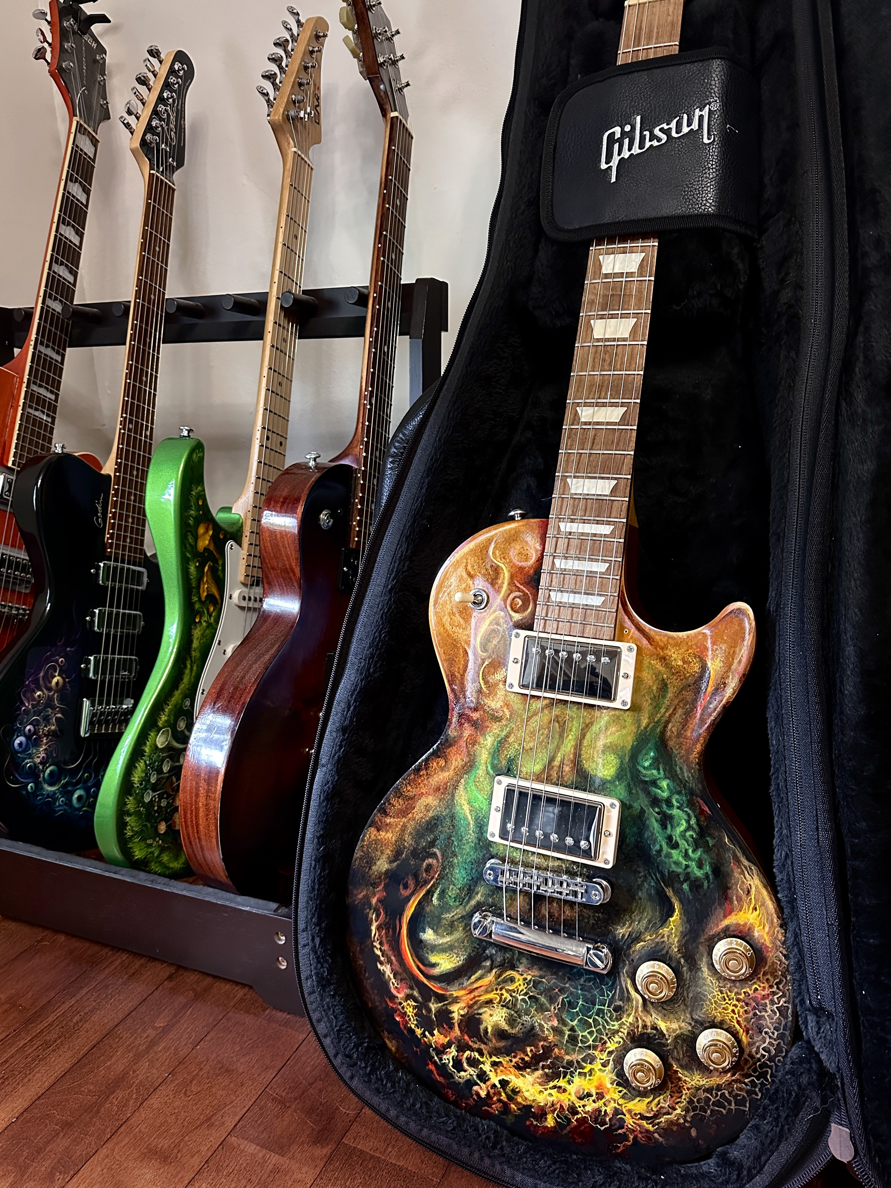 A studio view of several distinct hand-painted guitars.